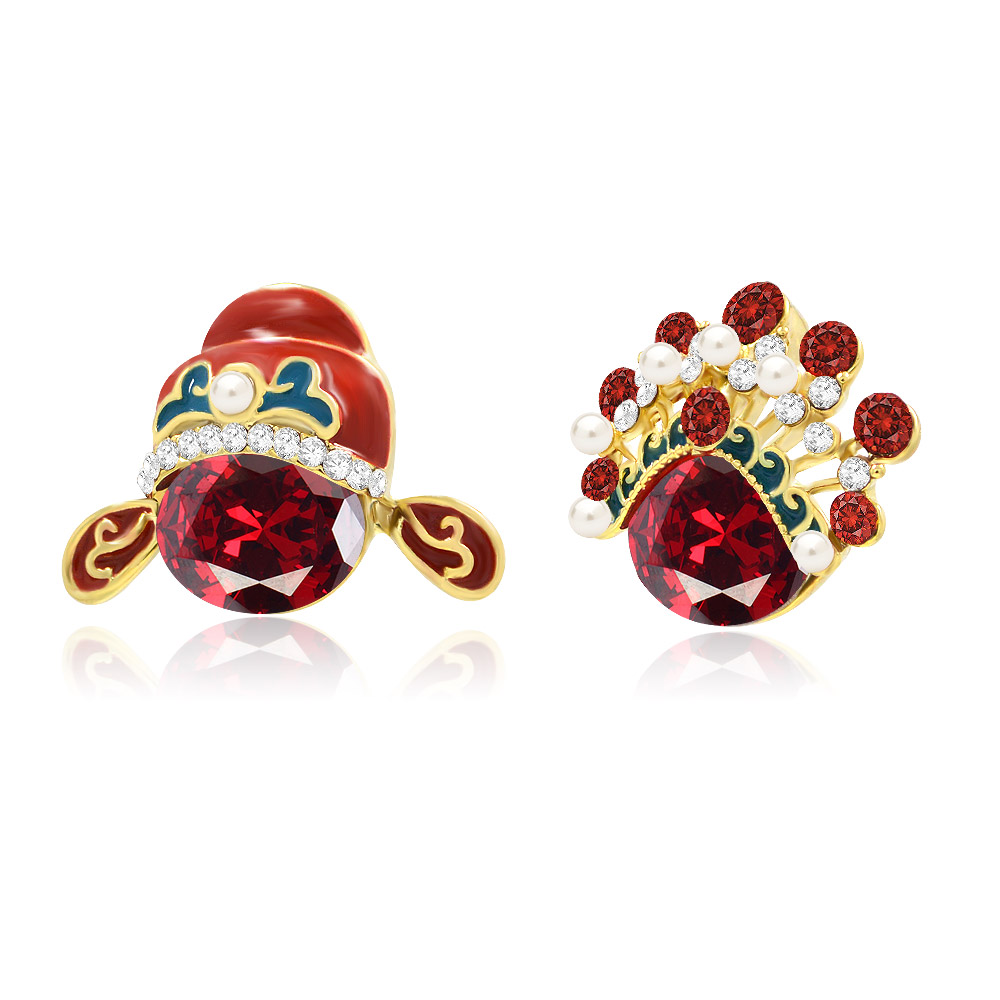 Detailed view of the Asymmetrical Opera Mask Earrings showcasing the red gemstone and gold setting.