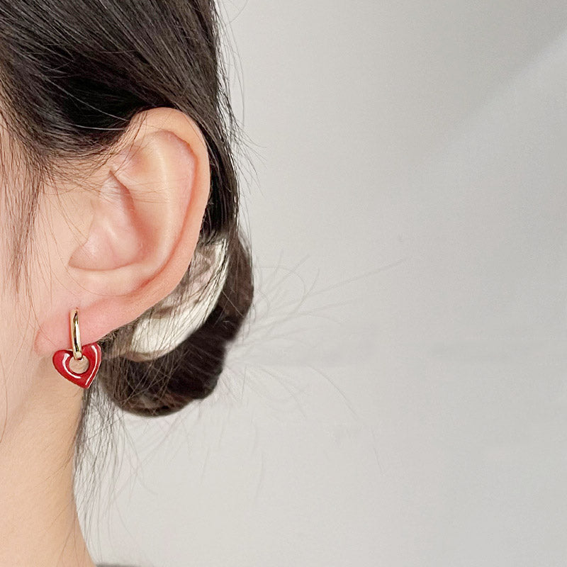 A woman wearing the red heart-shaped earring to show its elegant look.