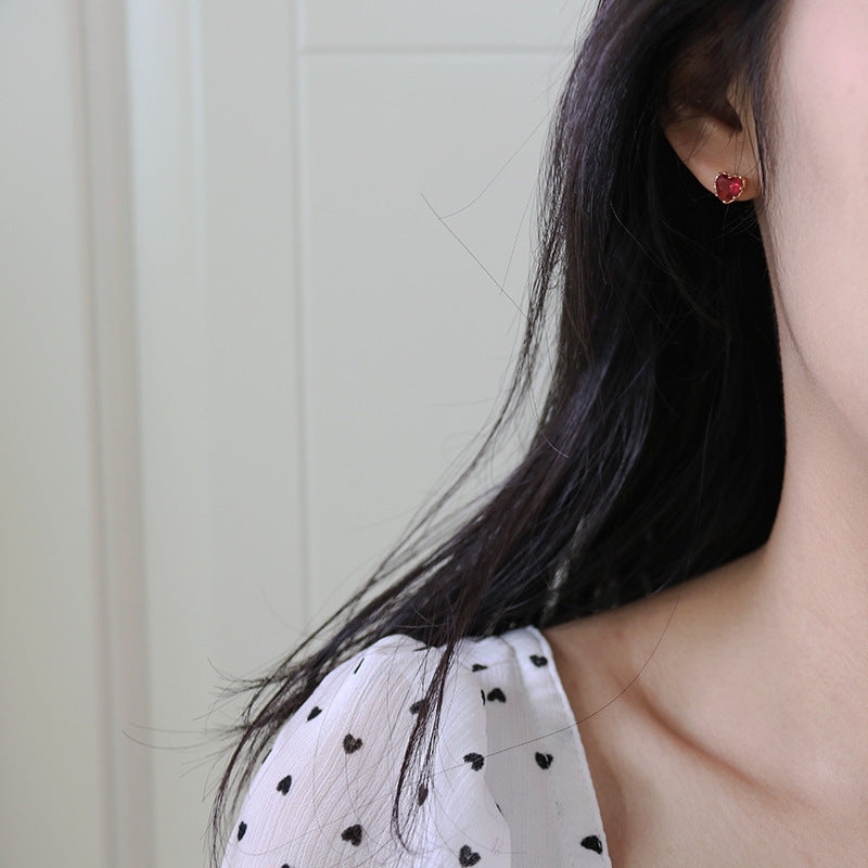 Model showcasing the 925 sterling silver red heart stud earring