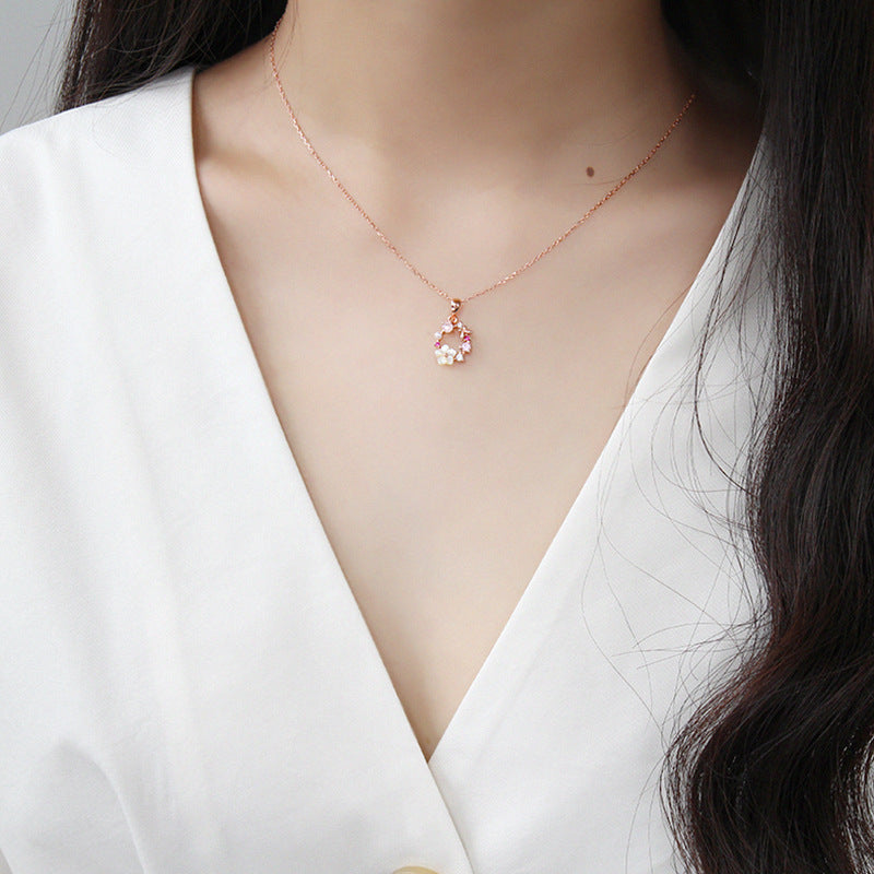 Model showcasing the delicate fit of the rose gold floral wreath necklace.