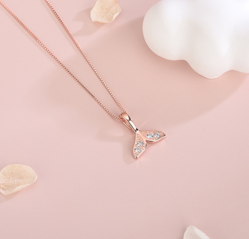 A detailed close-up of the rose gold mermaid tail pendant, showcasing its intricate design and sparkling cubic zirconia stones.