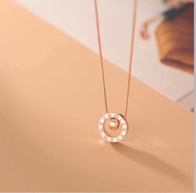 Close-up of the rose gold rotating pendant with Roman numerals