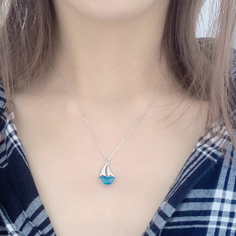 A model showcasing the elegant drape of the sterling silver sailboat necklace.
