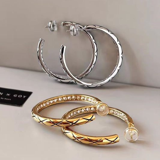 A collection of silver and gold plated brass hoop earrings showcasing different textures and designs.