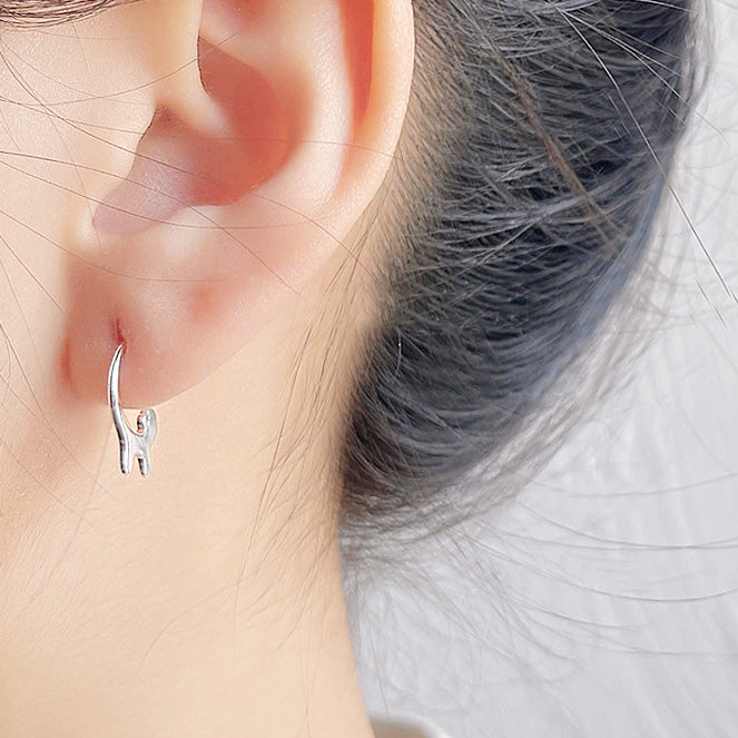 A woman wearing a silver animal-shaped earring
