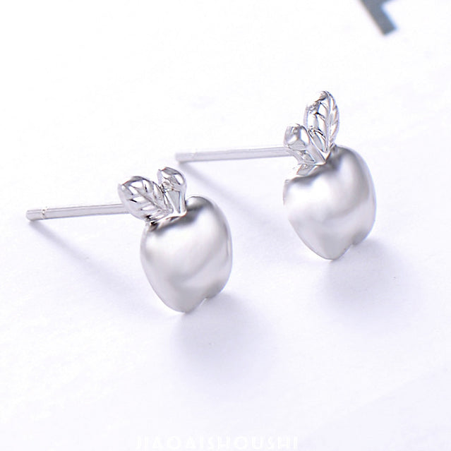 A detailed close-up of the silver apple earrings showcasing the polished finish and leaf detail.