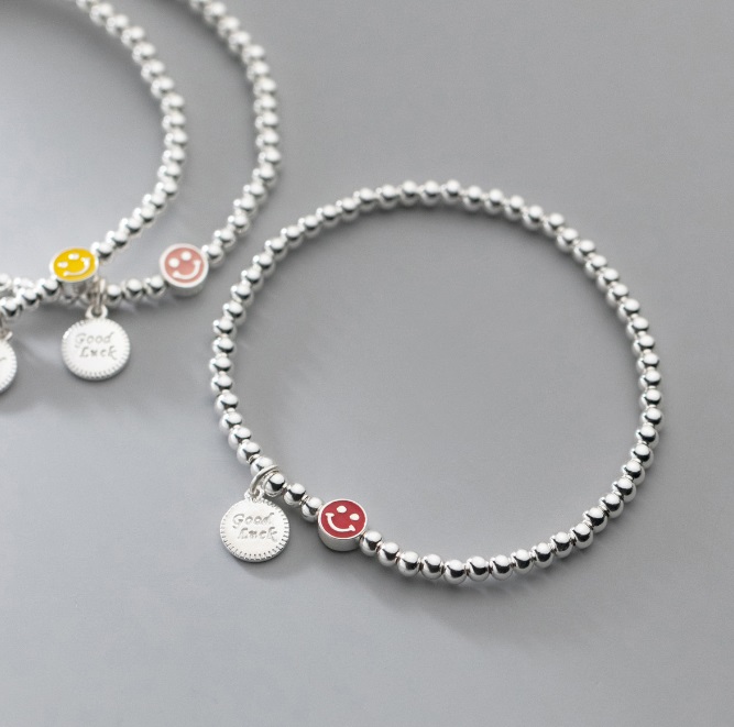 A pair of smiley face beaded bracelets showing the elastic design