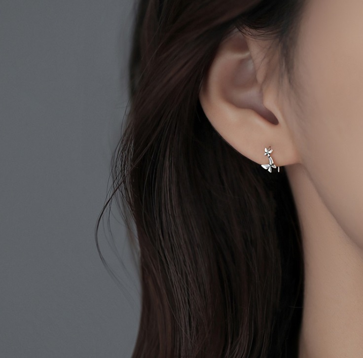 A model wearing the sterling silver butterfly dangle earrings to show the scale and style.