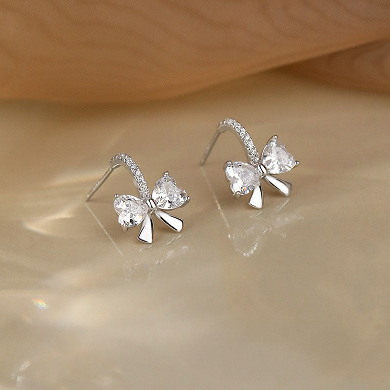 Detailed view of the elegant sterling silver knot-style earrings with diamond-like CZ stones