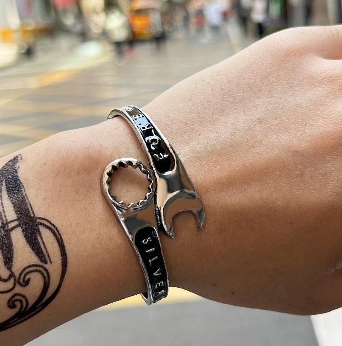 Men's tool bangle bracelet with a bottle opener feature shown on a wrist