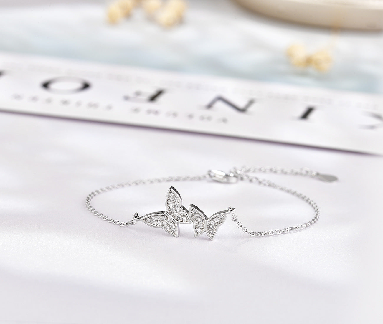 Detailed view of the silver butterfly bracelet with clear gemstones.