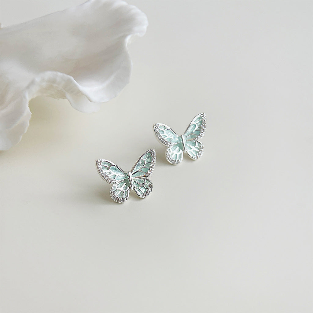 Detailed view of the mint green enamel butterfly earrings