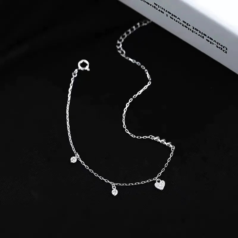 A close-up view of the 925 Sterling Silver Connected Hearts Charm Bracelet highlighting its intricate details and sparkling cubic zirconia.