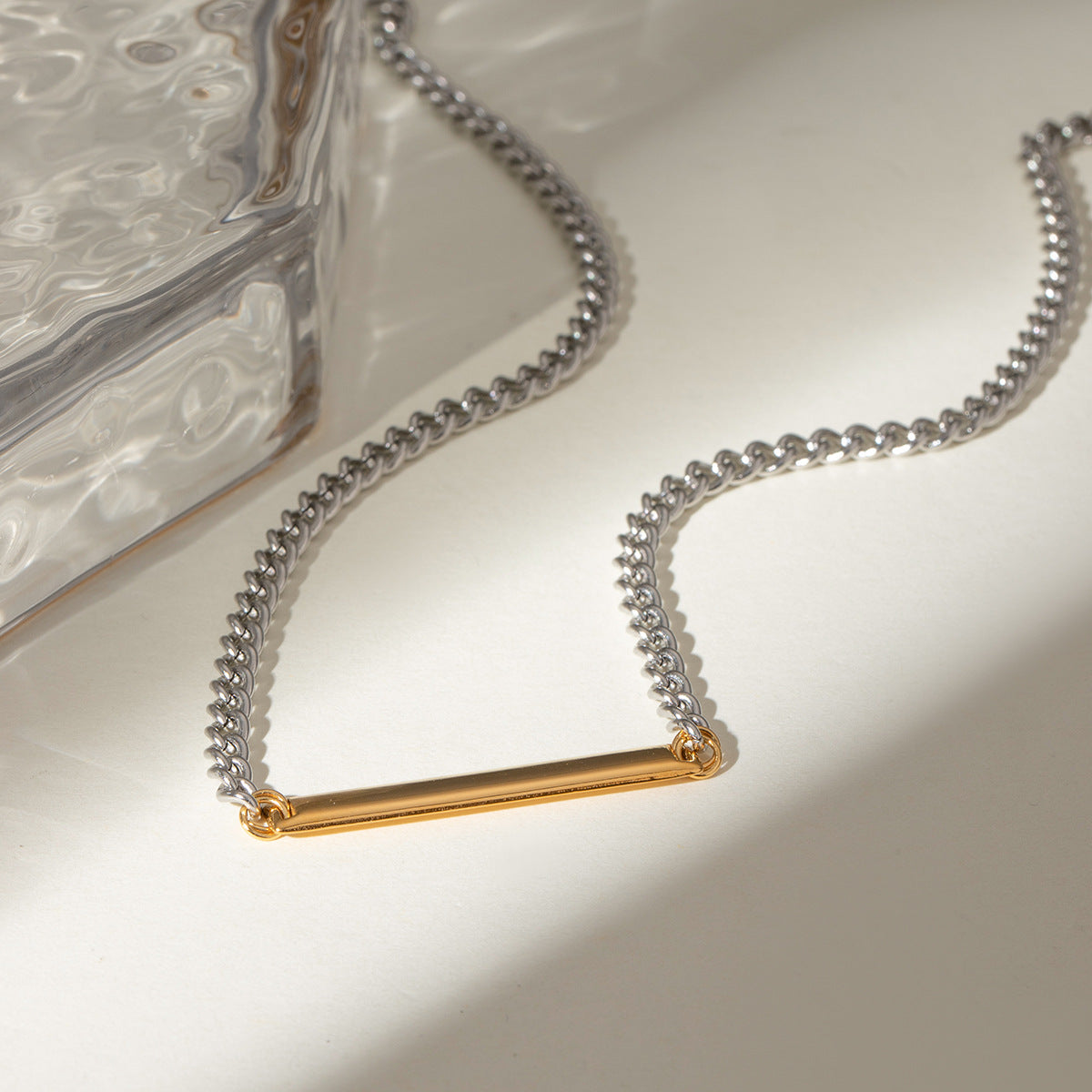 Model showcasing the minimalist two-tone bar pendant necklace