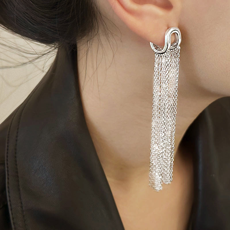 Model showcasing the elegant movement of the silver chain tassel earring.