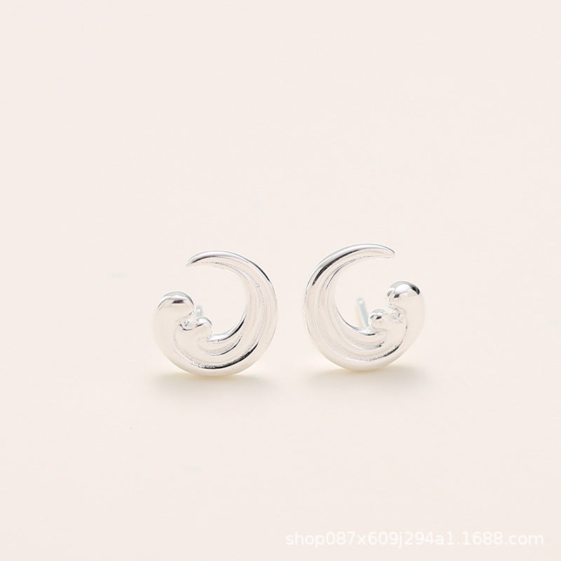 Detailed shot of the sterling silver wave stud earrings.