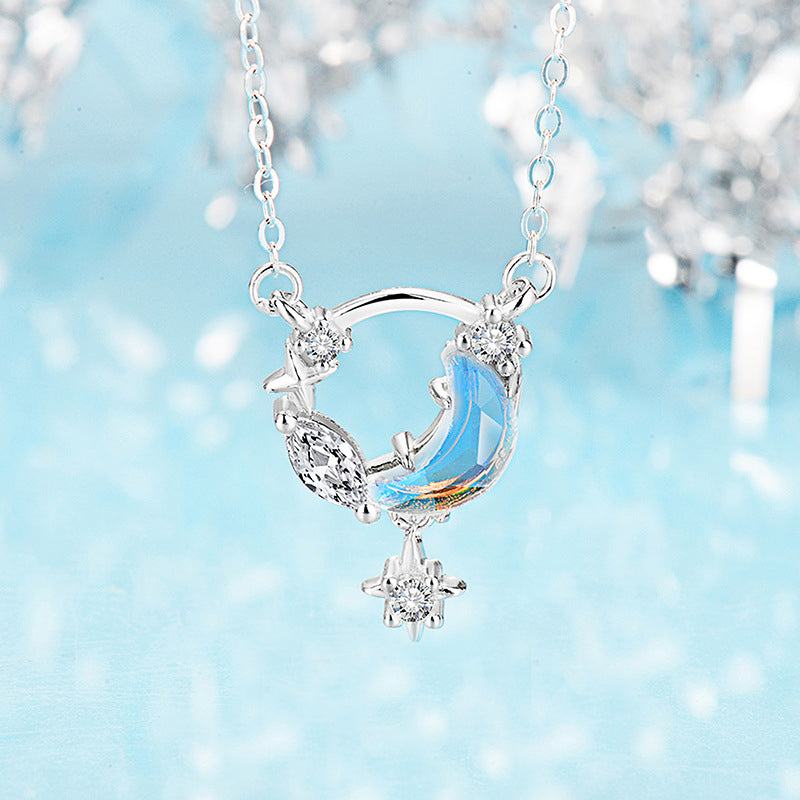 Detailed shot of a silver crescent moon necklace with blue gemstones