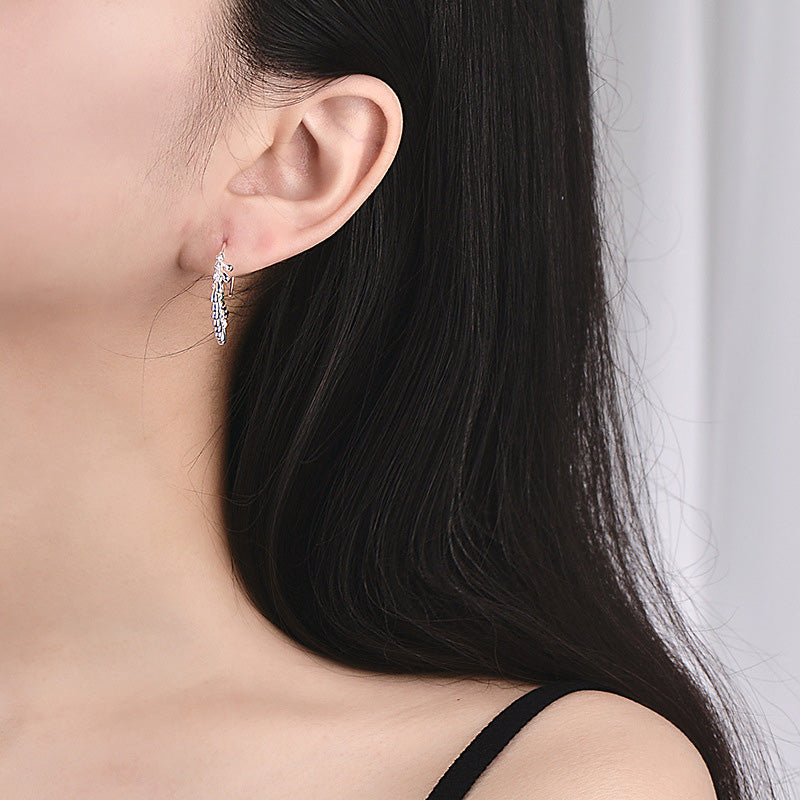 Model showcasing the dangle and fit of the hammered silver tassel earrings