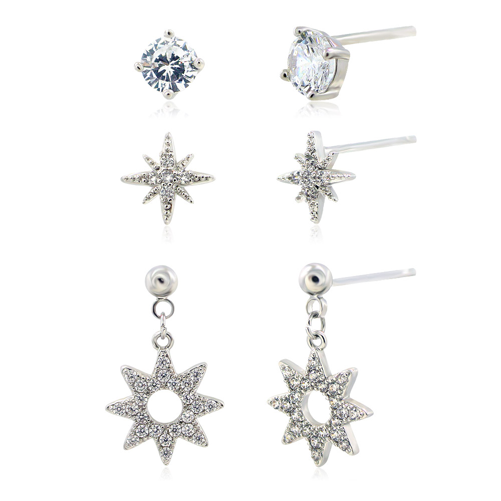 A collection of silver stud and dangling earrings with diamond accents displayed for wholesale.