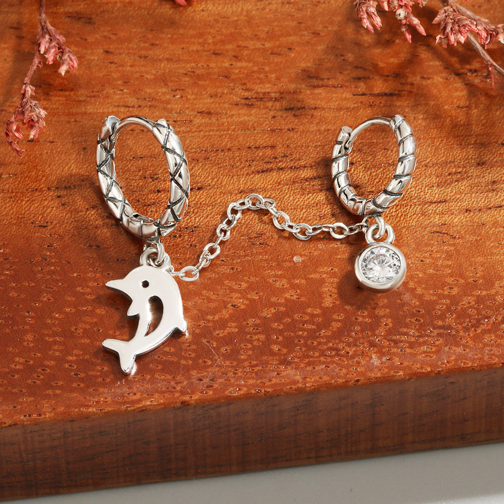 Close-up of the 925 sterling silver dolphin charm on the hoop earring