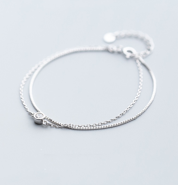 Detailed view of the solitaire charm on the double chain silver bracelet