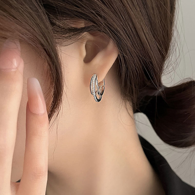 Detailed view of the CZ stones on the three-layer silver hoop earrings