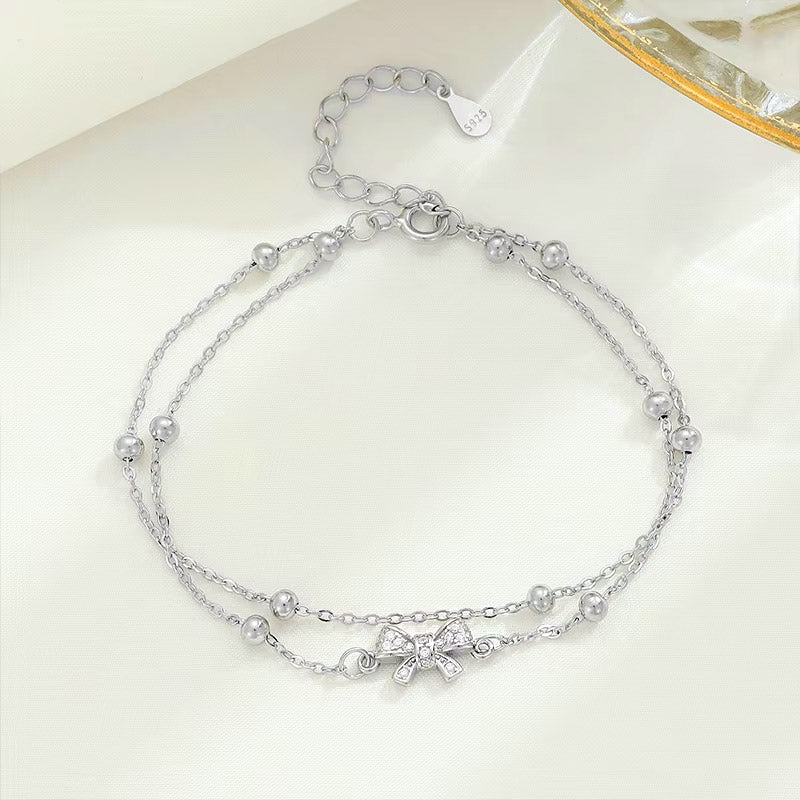Detailed view of the S925 double-strand bracelet with bow charm