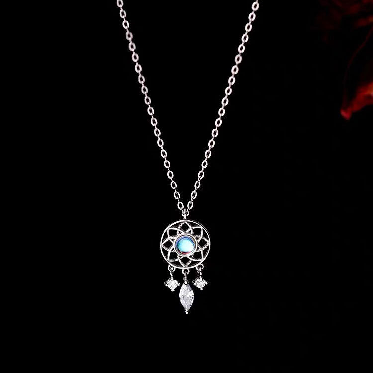 Detailed close-up of the silver dreamcatcher pendant with a blue moonlight stone.