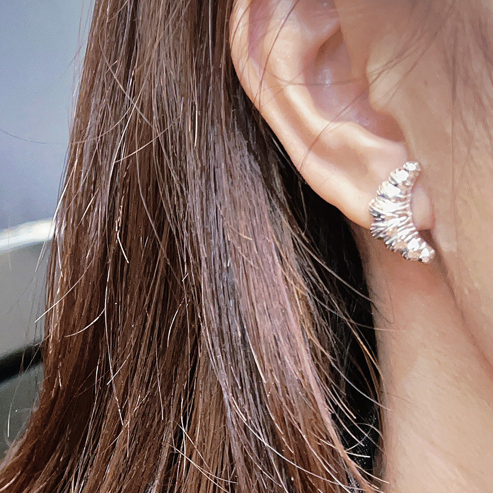 A model wearing the 925 sterling silver croissant stud earring.