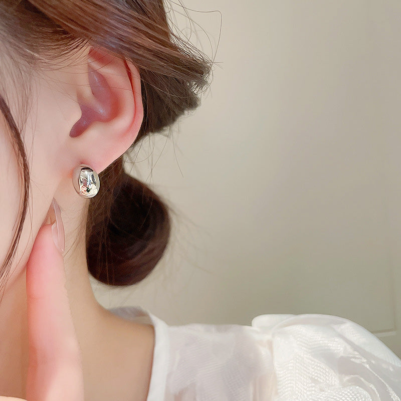 Model showcasing the elegant fit of the silver bean stud earring.