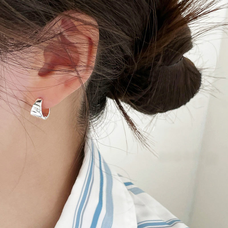 A model wearing the 925 sterling silver wide hoop earring to showcase its size and shine.