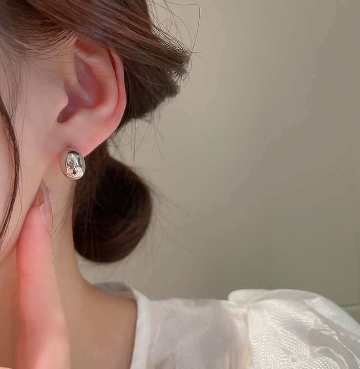 A model wearing the silver moon shape stud earring to display its elegant look and size.
