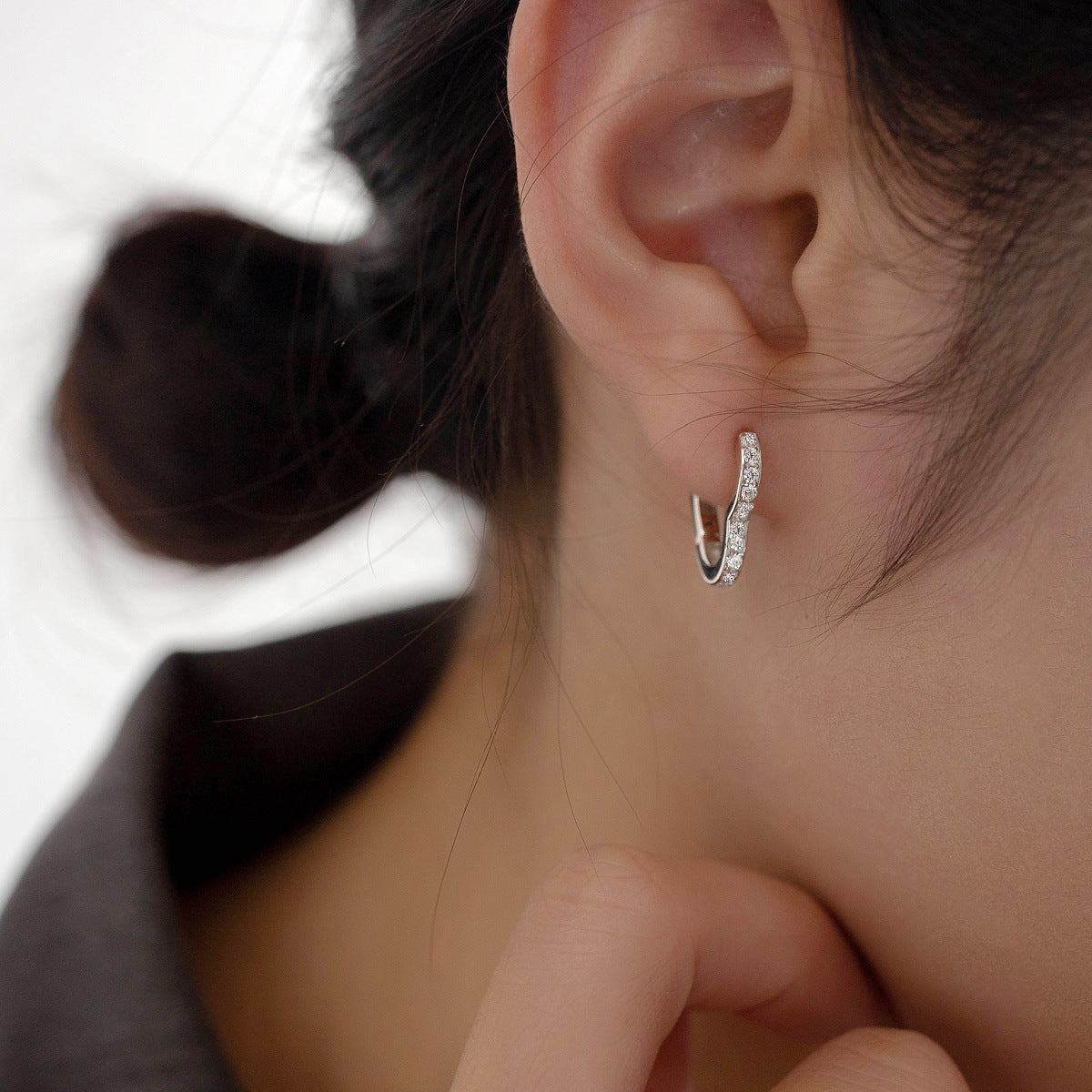 Model showcasing the elegant 925 sterling silver heart hoop earring.