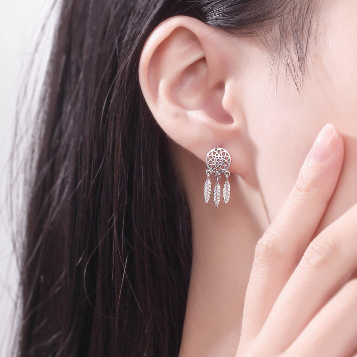 A model showcasing the silver dreamcatcher earring with feather dangles