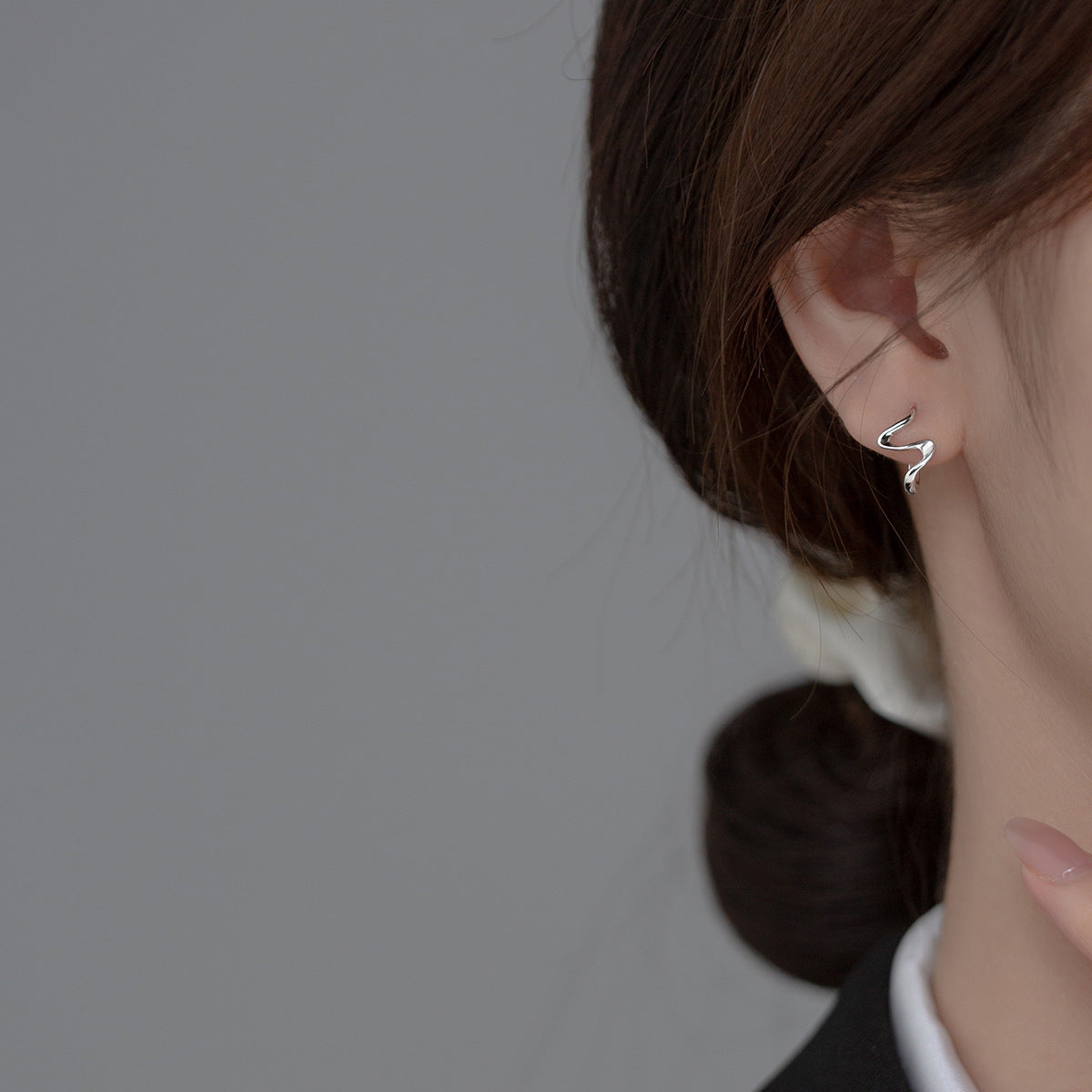 Model showcasing the elegant fit of the S925 silver wave cuff earring.