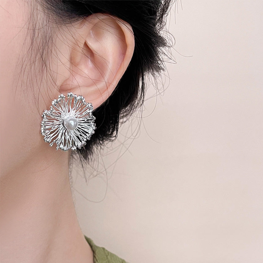 Model showcasing the elegant statement floral earrings with pearl center.