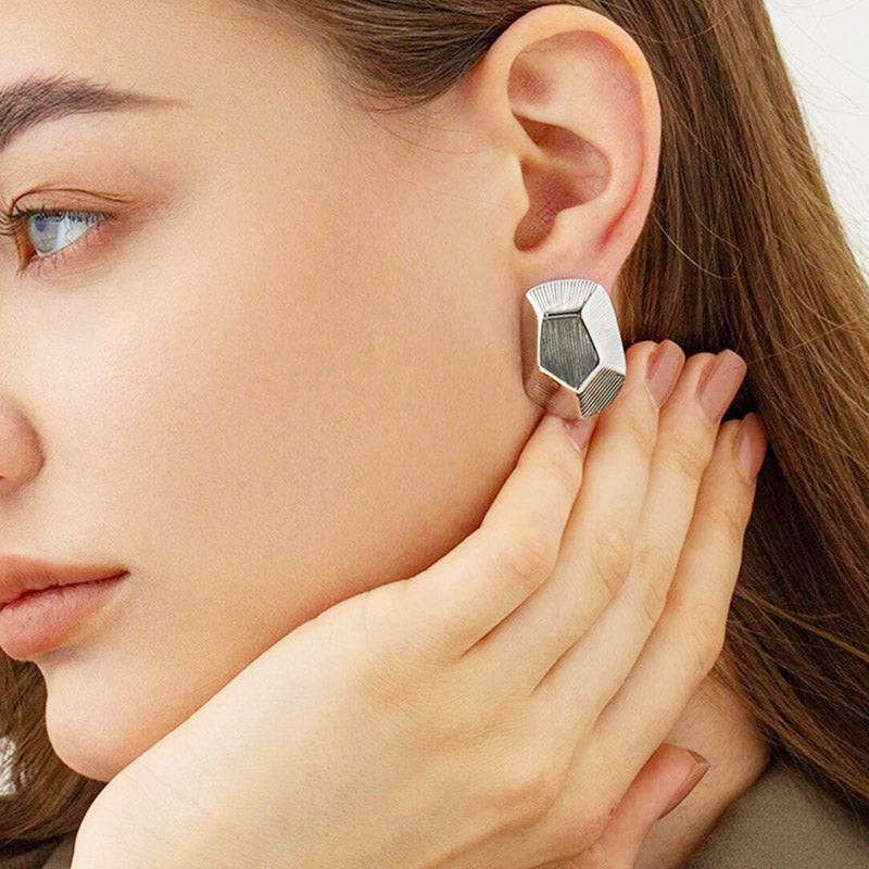 Model wearing the silver geometric pentagon earrings