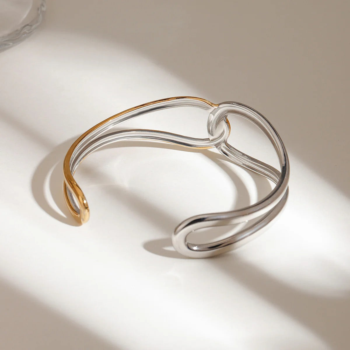 Close-up of the two-tone gold and silver open cuff bracelet design