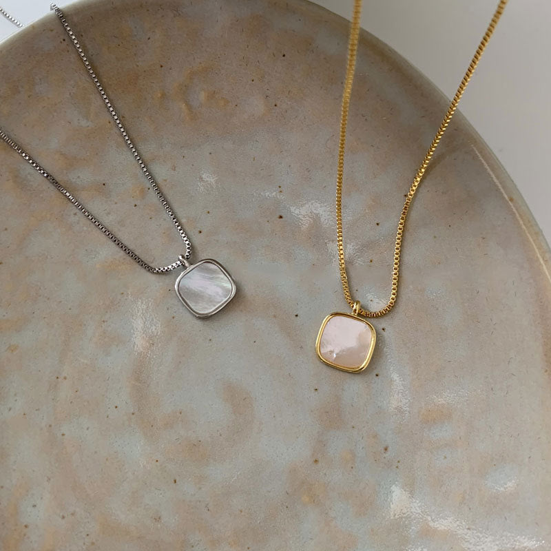 Both silver and rose gold versions of the seashell pendant necklace displayed together