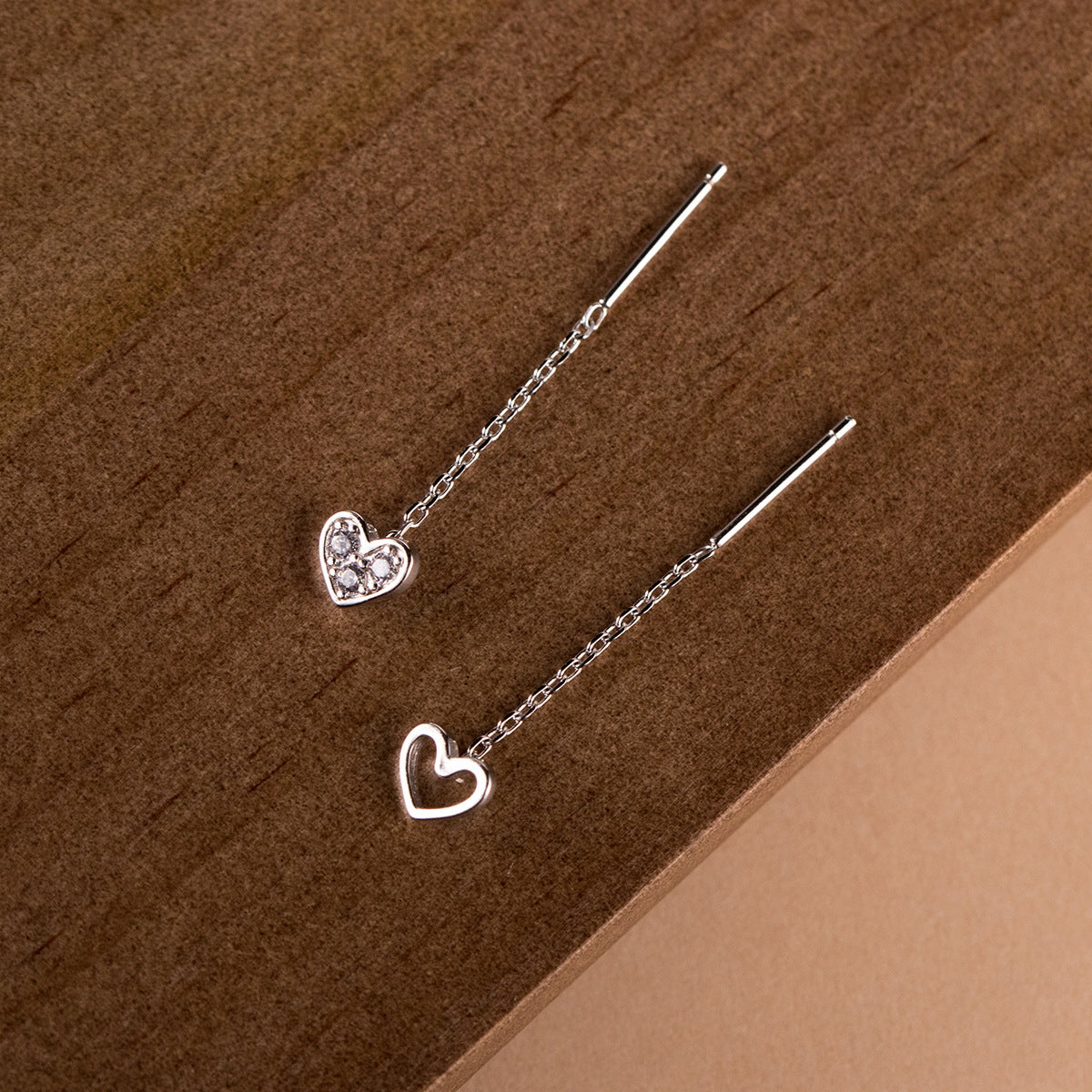 Detailed view of the hollow heart and solid zirconia heart earring designs.