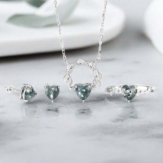 A beautiful 925 sterling silver jewelry set with heart-shaped moss agate stones, including a ring, necklace, and earrings.