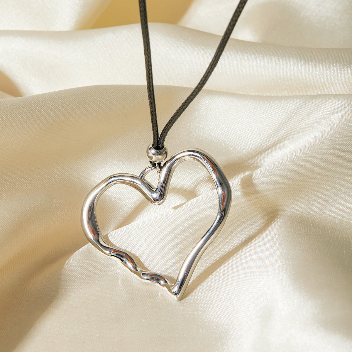 Silver stainless steel hollow heart pendant on a leather cord
