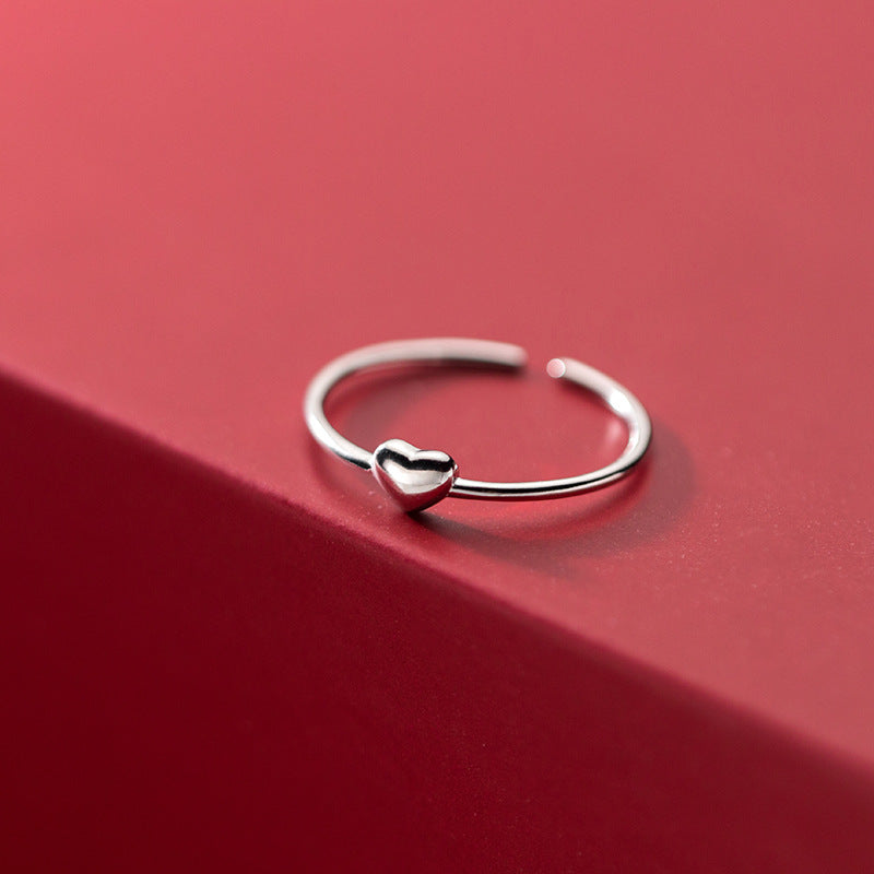 A single 925 sterling silver heart ring with an adjustable open band.