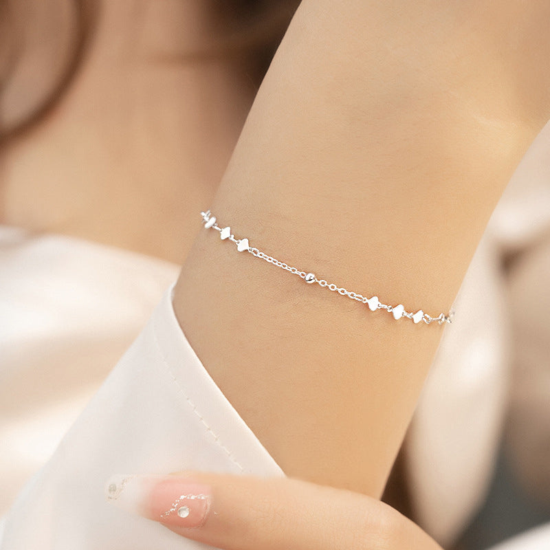 Model wearing the 925 sterling silver heart charm bracelet.