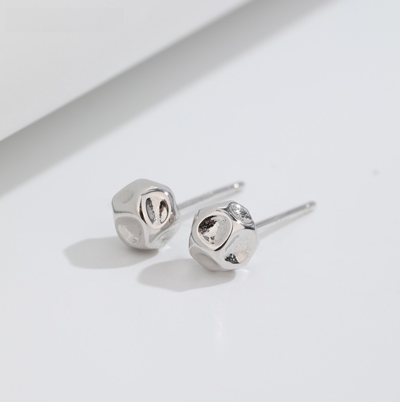 Close-up detail of the silver hammered stud earring's texture