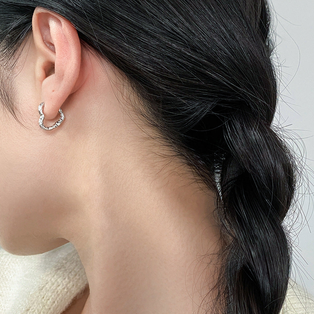 Model wearing the minimalist 925 silver textured heart hoop earrings