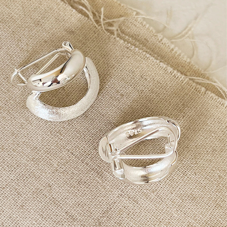 Close-up view of the S925 sterling silver stamp on the frosted hoop earrings