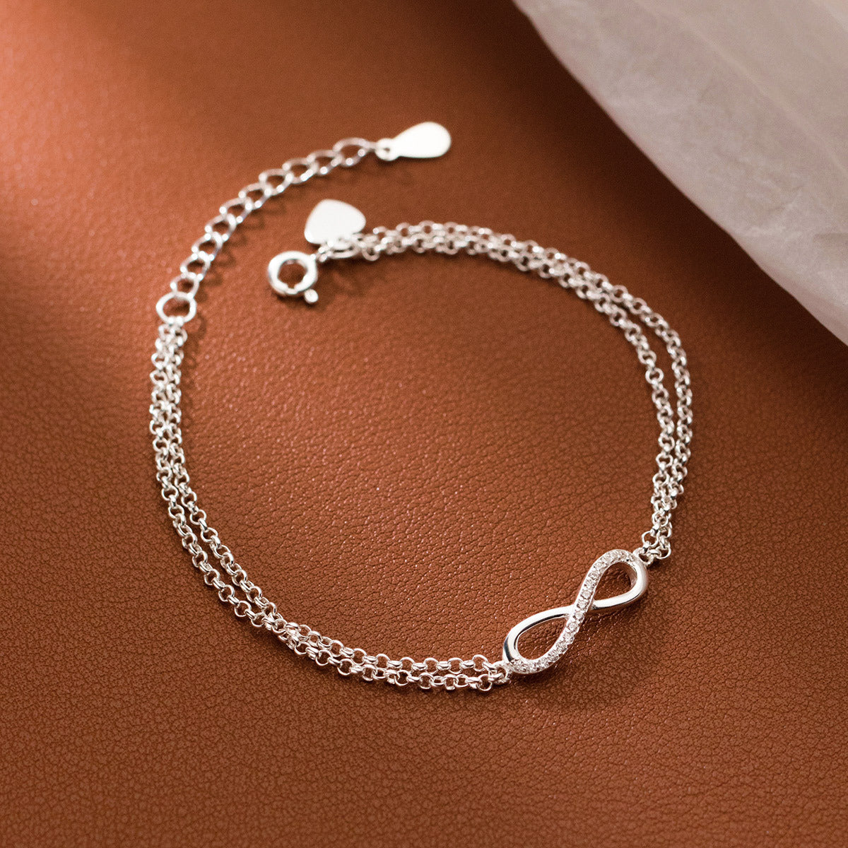 Close-up of the 925 sterling silver infinity bracelet on a textured surface