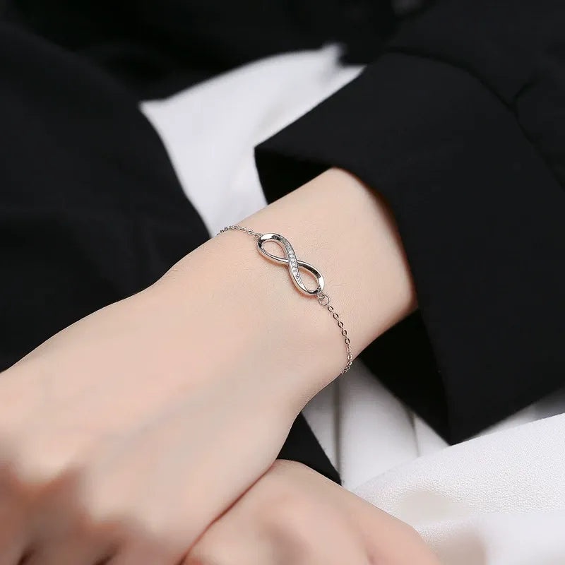 A woman wearing the sterling silver infinity bracelet, showing its elegant fit on the wrist.