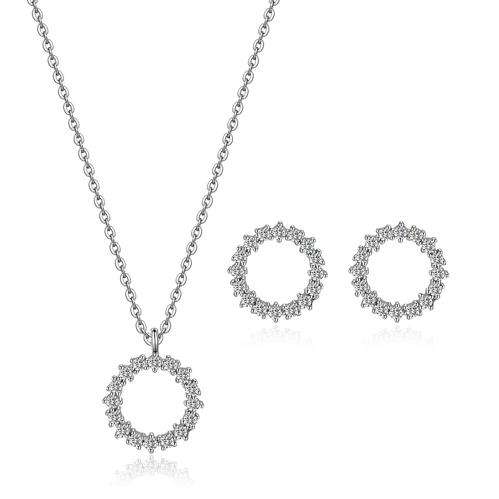 A silver-toned jewelry set including a necklace and earrings with circular, floral-designed pendants made of small diamonds or crystals.